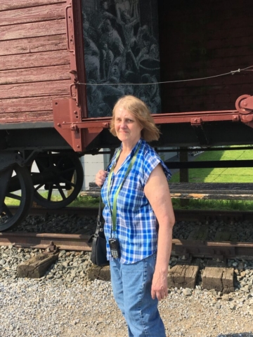 Debbie in front of train car used for prisoners Fort Breendonk